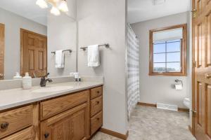 a bathroom with a sink and a toilet and a window at Kalbus House- Lake Winnebago access across the street in Oshkosh +14 photos