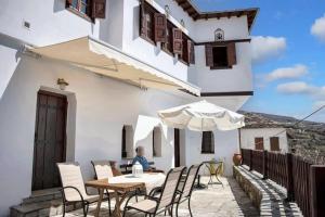 ヴォロスにある4 bedrooms house with sea view furnished terrace and wifi at Volos 6 km away from the beachの栗の上のテーブルに座る人