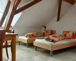 um quarto no sótão com 2 camas e uma secretária em Hotel Löwen em Mönchaltorf