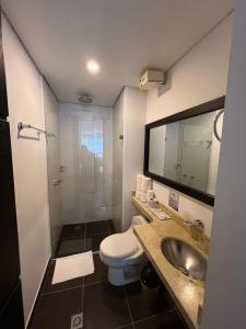 a bathroom with a toilet and a sink and a shower at Hotel H53 in Sogamoso