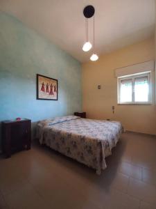 Schlafzimmer mit einem Bett und einem Fenster in der Unterkunft Casa vacanze a 100mt dal mare in Torre Ovo
