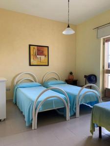 ein Krankenhauszimmer mit 2 Betten und blauer Bettwäsche in der Unterkunft Casa vacanze a 100mt dal mare in Torre Ovo