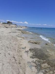 einen Strand mit Felsen und dem Meer an einem sonnigen Tag in der Unterkunft Casa vacanze a 100mt dal mare in Torre Ovo