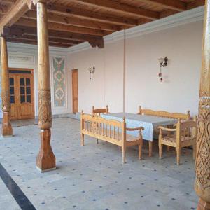 a room with a table and two benches in it at Шербудин in Bukhara