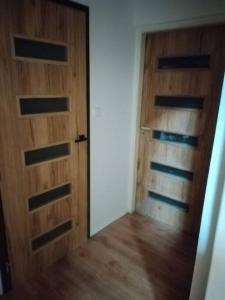 an empty room with two wooden doors and wooden floors at Love Home in Horní Heršpice
