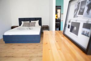 a bedroom with a bed and a framed picture at Studio Apartment in Warszawa Wola in Warsaw