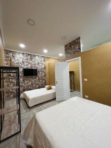 ナポリにあるB&B Caracciolo 109のベッドルーム1室(ベッド2台、壁掛けテレビ付)