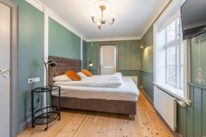 una camera da letto con pareti verdi e un letto con cuscini arancioni di Day Dream Historical Grjótagata 4 a Reykjavik