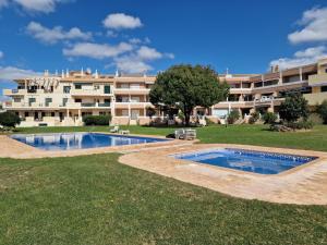 een groot appartementencomplex met twee zwembaden in een tuin bij Apartment T2 Cassias by Interhome in Vilamoura