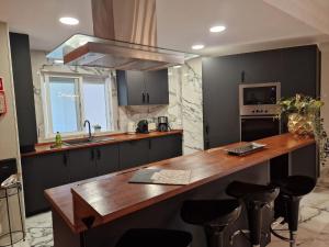 een keuken met een houten aanrecht en zwarte kasten bij Apartment T2 Cassias by Interhome in Vilamoura