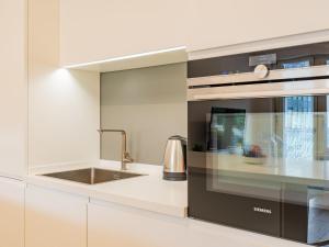 a kitchen with a sink and a microwave at Apartment Am See by Interhome in Riva del Garda
