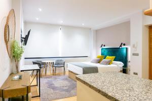 um quarto de hotel com uma cama e uma mesa em Suite Andrés Pérez Málaga Center em Málaga