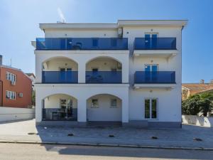 un edificio blanco con balcones azules en Studio Villa Amra-3 by Interhome, en Poreč