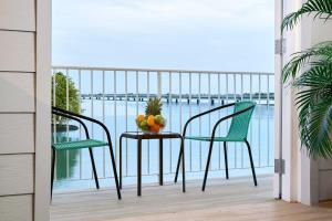 einen Balkon mit 2 Stühlen und einem Tisch mit Obst darauf in der Unterkunft Casa La Costa By Wynwood House in Panama-Stadt
