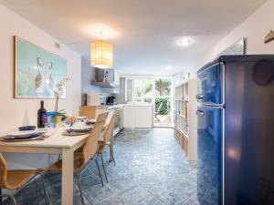 a kitchen with a table and a refrigerator at Holiday Home Le Mandrie by Interhome in Punta Ala