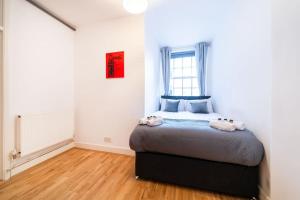 Beautiful one bedroom flat in Tavistock Place في لندن: غرفة نوم مع سرير في غرفة مع نافذة