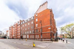a large red brick building on a city street at Beautiful one bedroom flat in Tavistock Place in London