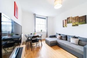 Beautiful one bedroom flat in Tavistock Place في لندن: غرفة معيشة مع أريكة وطاولة