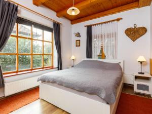 a bedroom with a bed and two windows at Holiday Home Magnolia by Interhome in Látrány