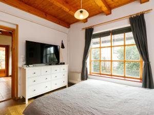 a bedroom with a bed and a television on a dresser at Holiday Home Magnolia by Interhome in Látrány