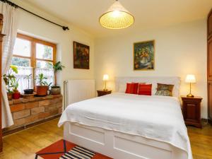 a bedroom with a large white bed and two lamps at Holiday Home Magnolia by Interhome in Látrány