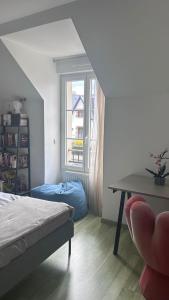 - une chambre avec un lit, une table et une fenêtre dans l'établissement Maison proche Paris-Versailles, à Igny