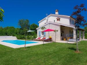une villa avec une piscine en face d'une maison dans l'établissement Villa Azura by Interhome, à Marčana