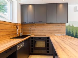 una cucina con armadi neri e ripiano in legno di Holiday Home Park Residence 12 by Interhome a Balatonszárszó Altre 58 foto