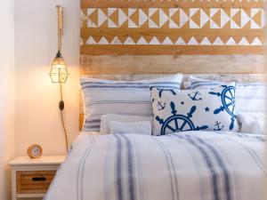 a bed with blue and white sheets and pillows at Apartment Salty Seadog by Interhome in Treknow