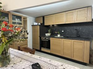 a kitchen with wooden cabinets and a table with flowers at Apartment Casa Lulú by Interhome in San Lorenzo al Mare +83 photos