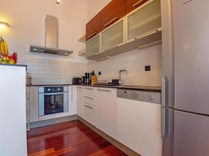 Una cocina con gabinetes blancos y un refrigerador. en Holiday Home Paola by Interhome, en Brodarica