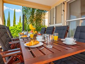 Una mesa de madera con comida y bebidas en un patio. en Holiday Home Paola by Interhome, en Brodarica