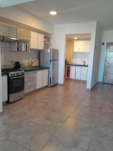 バイアブランカにあるDepto SL74の広いキッチン(白いキャビネット、ステンレス製の電化製品付)