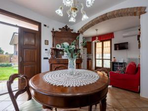 una mesa de comedor con un jarrón de flores. en Holiday Home La Casa del Nonno by Interhome, en Montegrosso dʼAsti