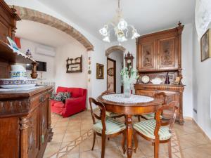 Montegrosso dʼAstiにあるHoliday Home La Casa del Nonno by Interhomeのダイニングルーム(テーブル、赤いソファ付)