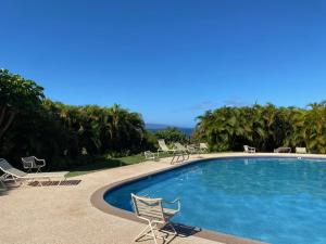 a large swimming pool with chairs and tables andorians at Maui Paradise Townhouse in Wailea