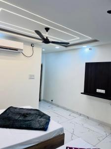 a room with a ceiling fan and a tv at Hotel shree vaikuntha palace ( वैकुण्ठ पैलेस ) in Ujjain