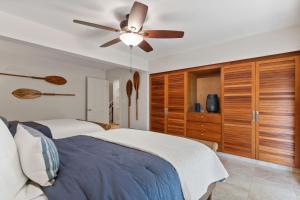 a bedroom with two beds and a ceiling fan at Maui Paradise Townhouse in Wailea