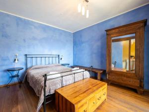 CortemiliaにあるApartment Quadrilocale 19 by Interhomeの青い壁のベッドルーム(ベッド1台、鏡付)