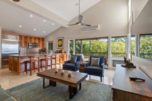 a living room with a table and a kitchen at Maui Paradise Townhouse in Wailea