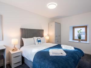 a bedroom with a bed with a blue blanket at Studio Harbour Nights 7A by Interhome in Lossiemouth