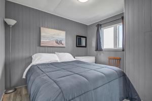 - une chambre avec un grand lit et une fenêtre dans l'établissement Cape View Motel & Cottages, à Mavillette