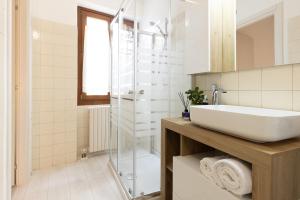 a bathroom with a sink and a glass shower at AnticaValle Intero Appartamento in Verona