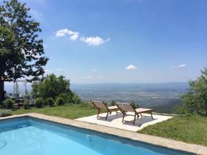 a swimming pool with two chairs and a view at Holiday Home Bellavista by Interhome in Cortona
