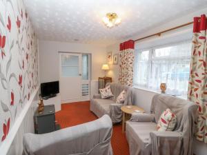 a living room with two couches and a tv at Ground Floor Apartment in Porthmadog