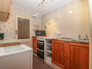 cocina con fregadero y fogones horno superior en Ground Floor Apartment en Porthmadog