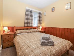 1 dormitorio con 1 cama, 2 lámparas y ventana en Ground Floor Apartment en Porthmadog