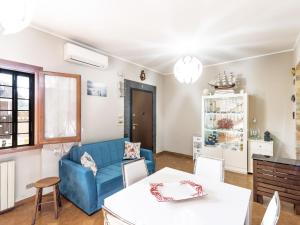 uma sala de estar com um sofá azul e uma mesa em Holiday Home Mimosa by Interhome em Lido dei Pini