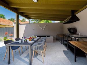 an outdoor patio with tables and chairs and a couch at Holiday Home Park Residence 19 by Interhome in Balatonszárszó