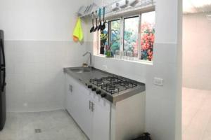 a white kitchen with a stove and a window at Rest 1 in Santa Marta